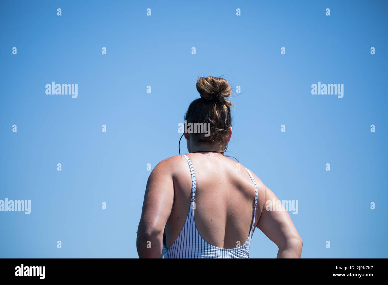 Un faible angle d'une femelle caucasienne vue de derrière, dans un maillot de bain contre un ciel bleu Banque D'Images