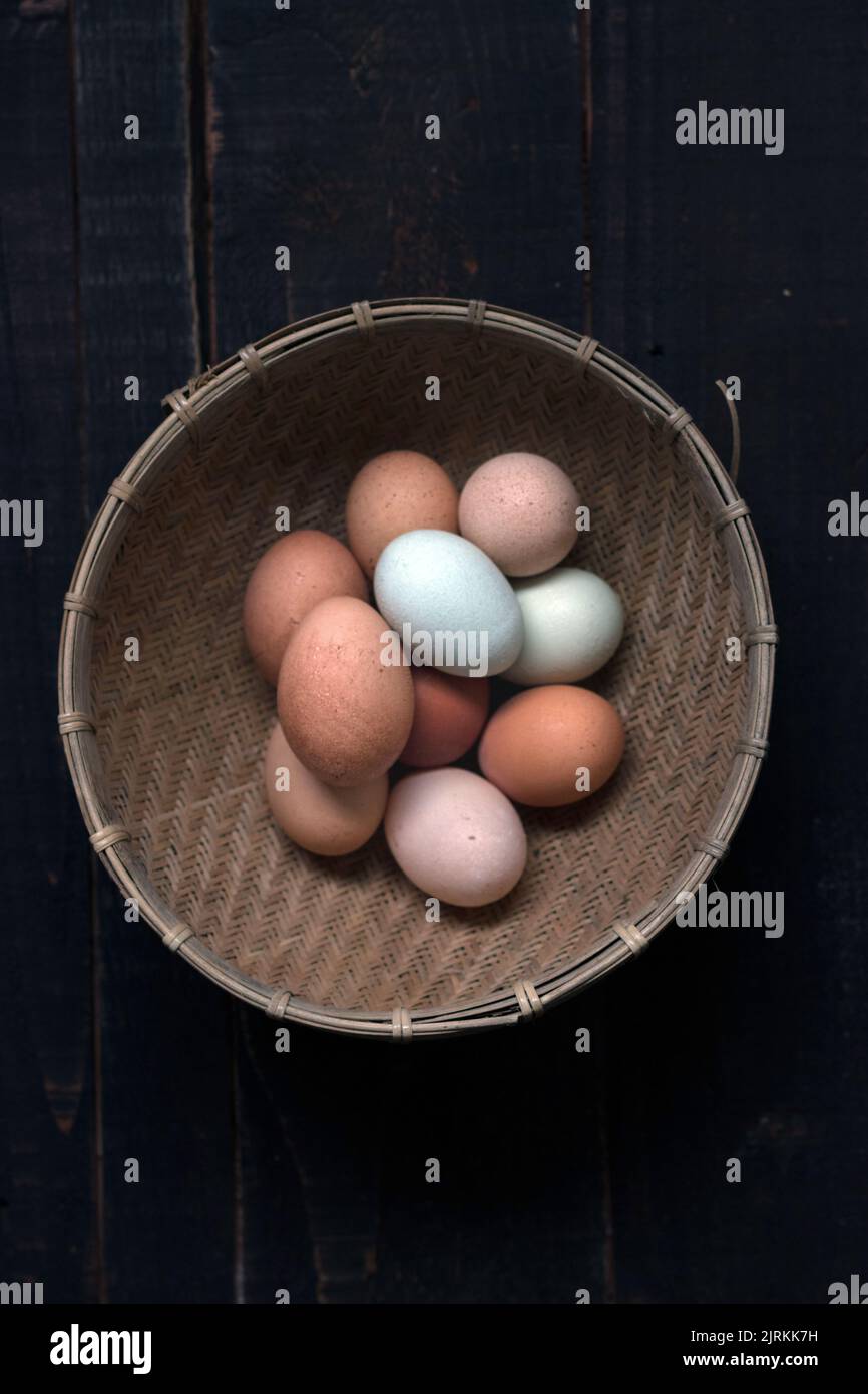 De la photo ci-dessus du panier en osier rempli d'œufs bruns et blancs sur la table Banque D'Images