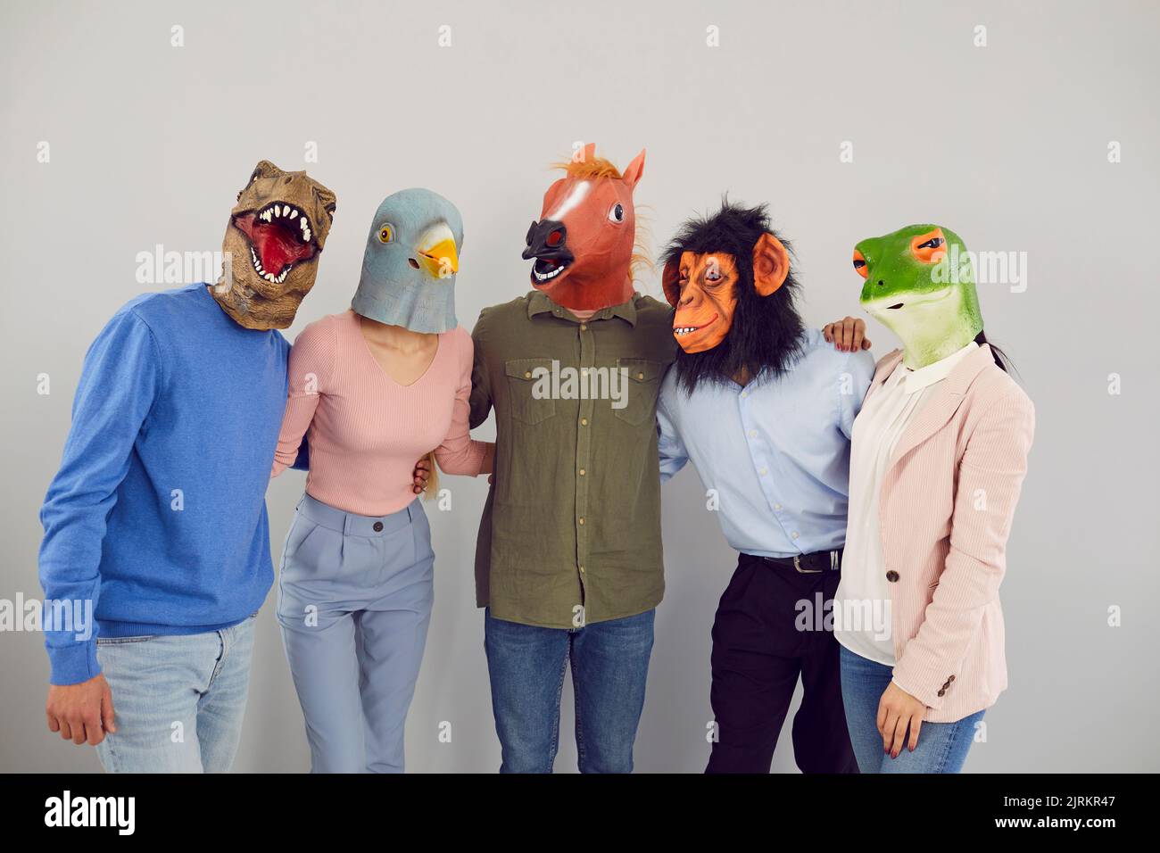 Jeunes gens gaies dans divers masques originaux sous forme de têtes d'animaux embrassant regardant l'appareil photo. Banque D'Images