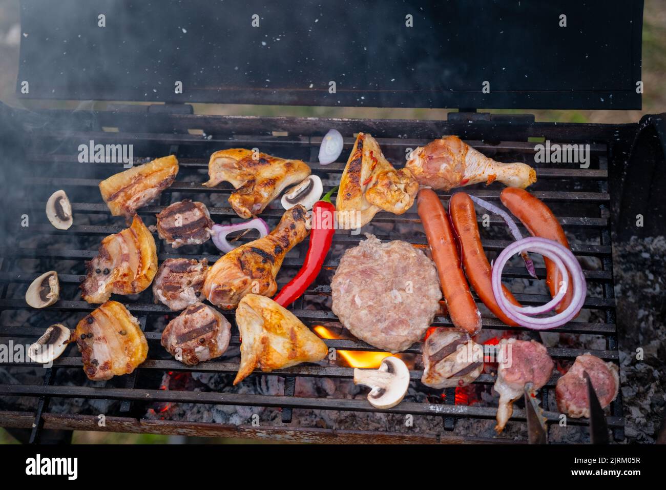 Un assortiment de légumes avec une délicieuse viande grillée sur les braises d'un barbecue Banque D'Images