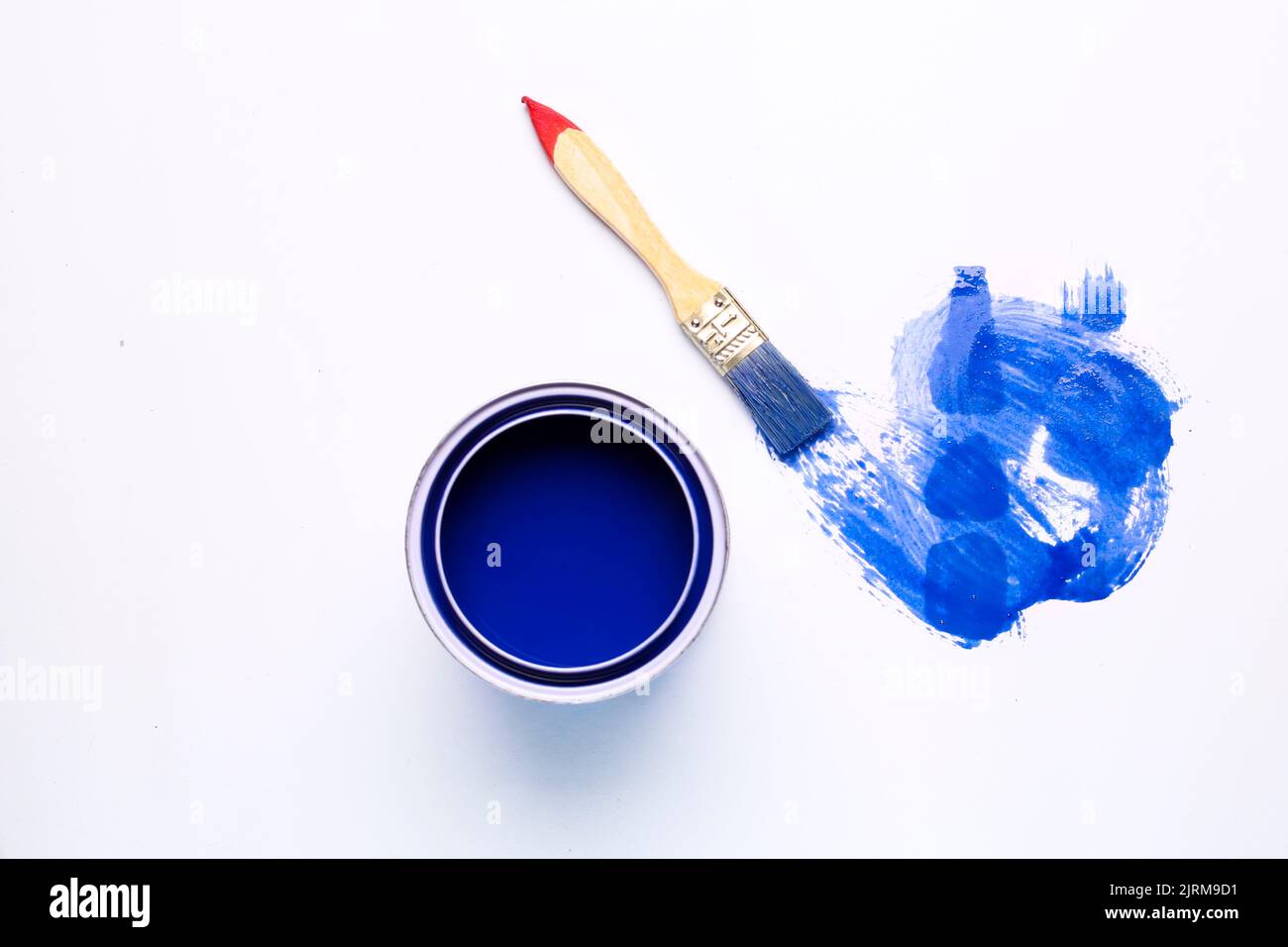des taches de peinture bleues et des boîtes de peinture sur fond blanc Banque D'Images