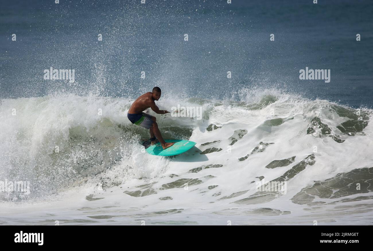 Un homme surfant sur les vagues tout en s'équilibrant sur le plateau Banque D'Images