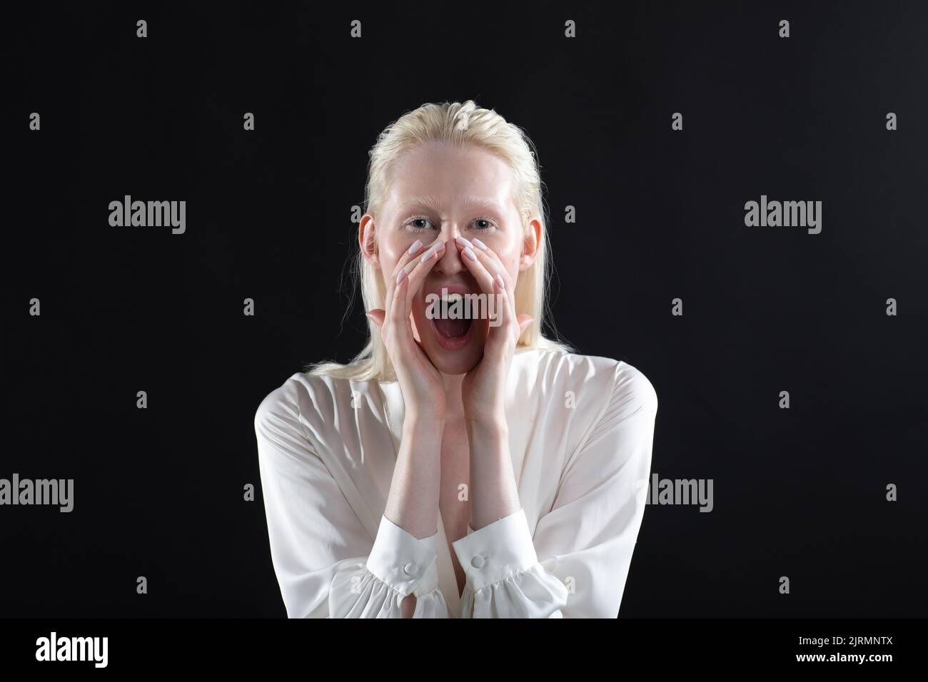 Portrait de la femme blonde blanche d'albinos caucasien tenant la main de la paume près de la large bouche ouverte criant cri Banque D'Images