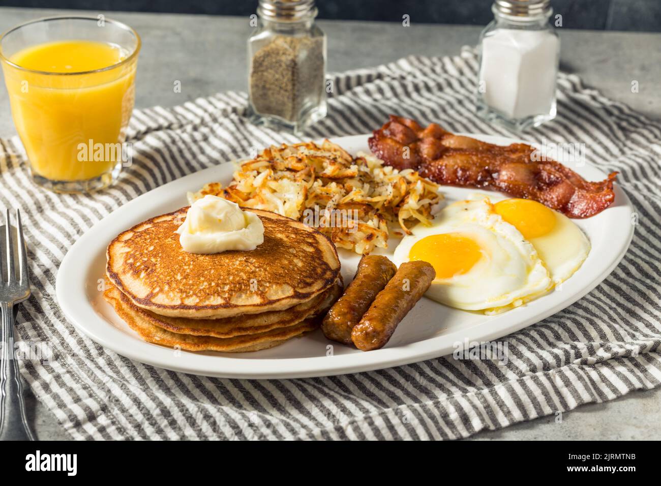 Petit-déjeuner américain à crêpes maison complet brunch avec œufs bacon et Hashbrowns Banque D'Images