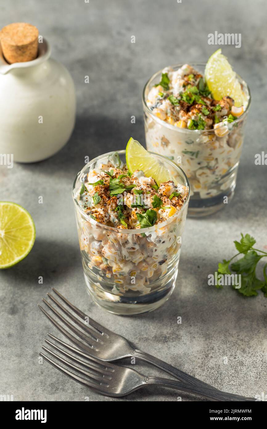 Esquites au maïs faits maison dans une tasse avec de la Mayo et de la chaux Banque D'Images