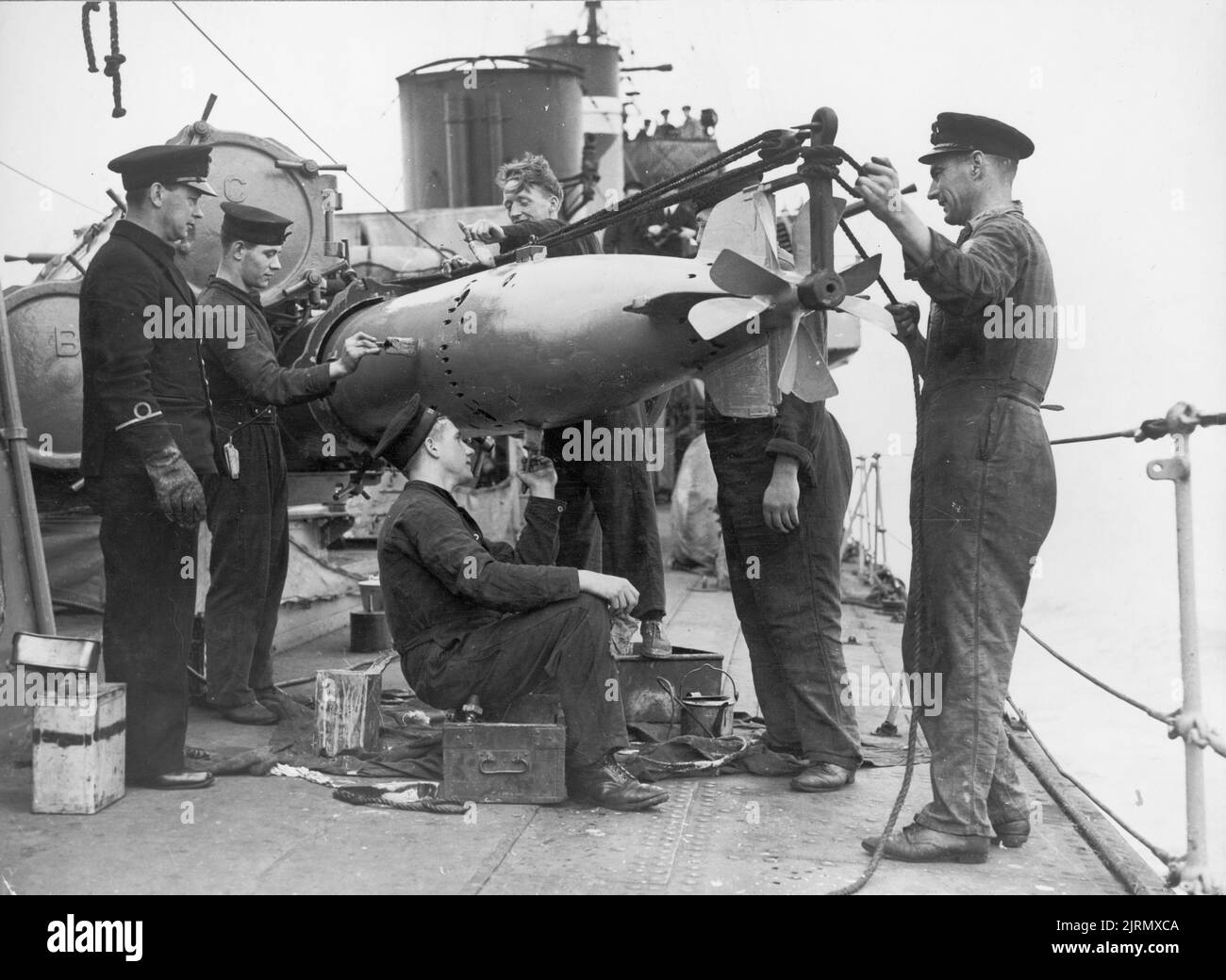 Une photo vintage vers 16 août 1941 montrant des marins britanniques chargeant une torpille dans un tube de torpille à bord du HMS COVAN un destroyer britannique de classe V qui a servi pendant la première et la deuxième guerre mondiale Banque D'Images