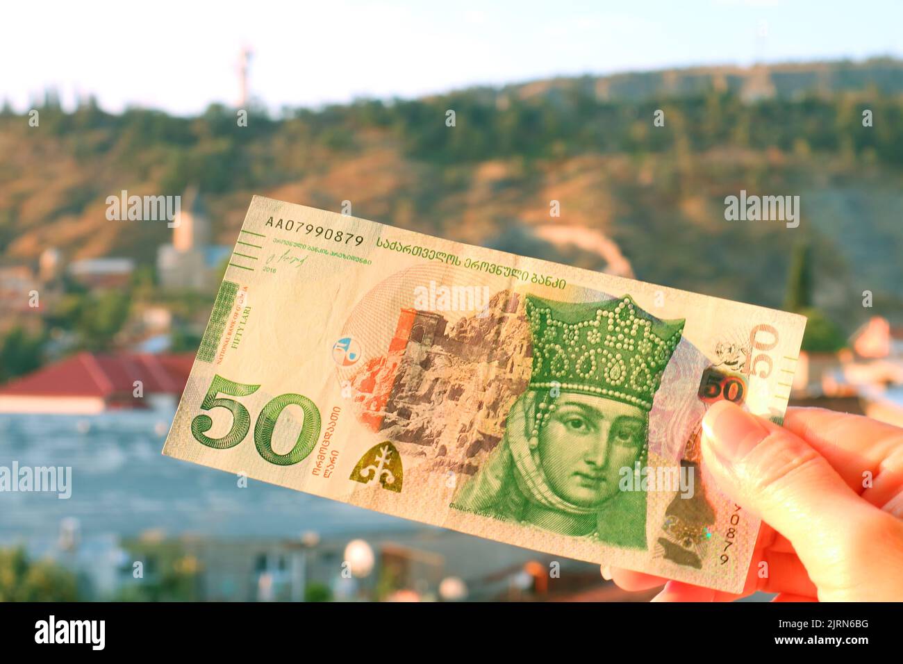 50 billets de banque géorgiens Lari en face de l'Obverse, avec vue floue de la ville de Tbilissi en toile de fond Banque D'Images