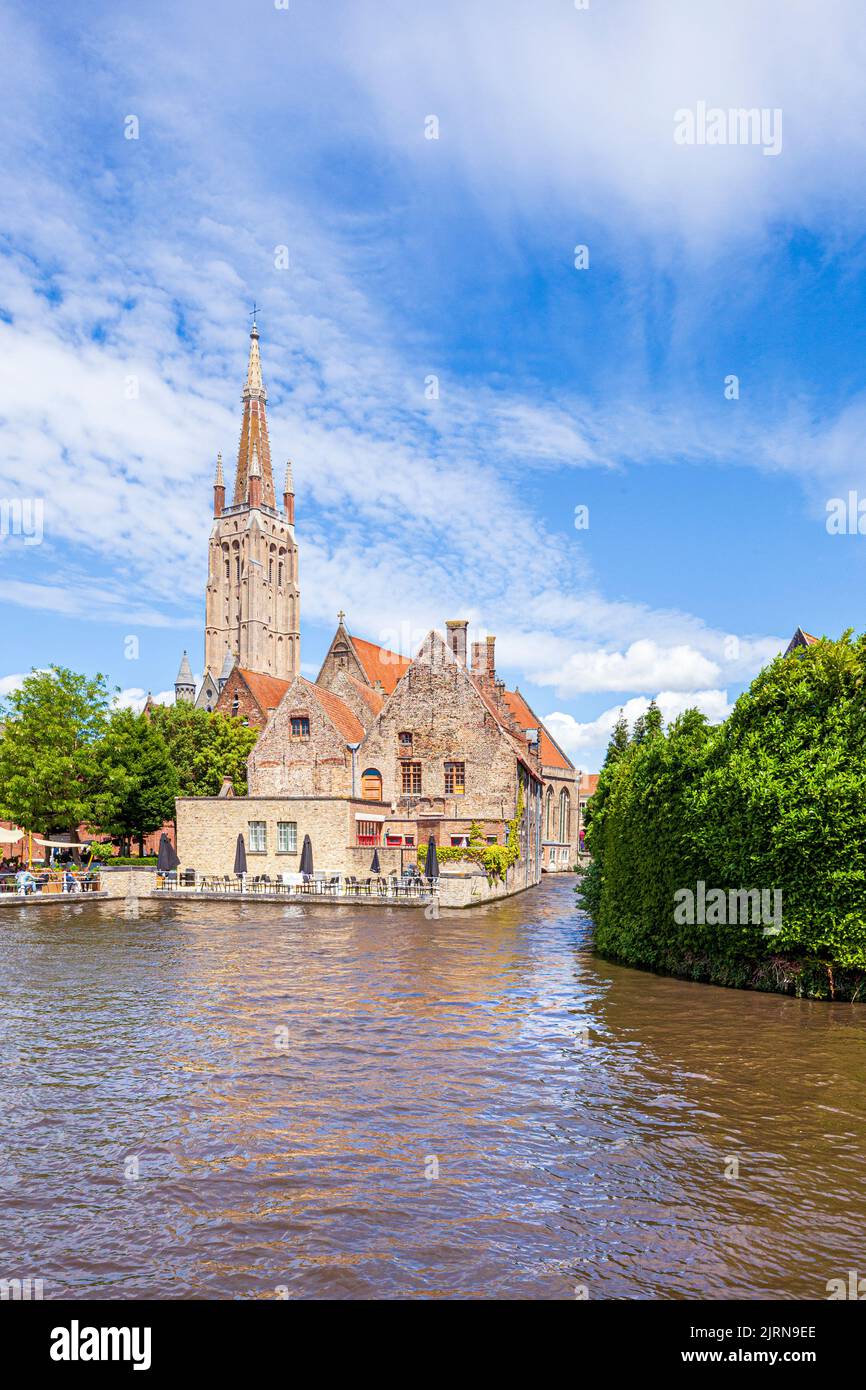 La flèche de l'église notre-Dame (onze-Lieve-Vrouwekerk) surplombant l'hôpital St Johns (Sint-Janshospitaal) et les vieilles maisons au bord du canal de Brug Banque D'Images