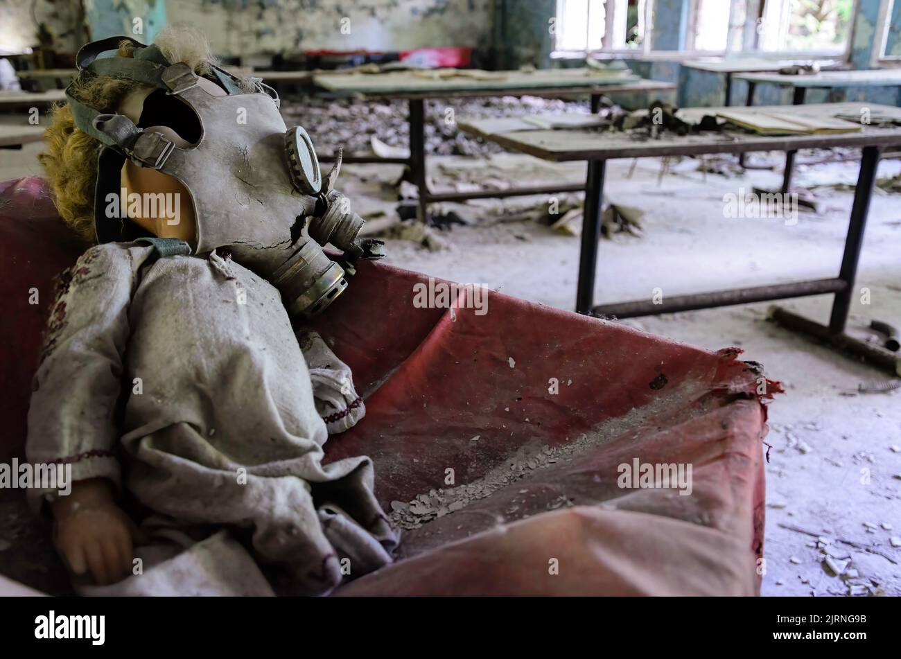 Masque à gaz sur la tête d'une poupée dans la salle de classe de Prypiat. Zone d'exclusion de Tchernobyl Banque D'Images