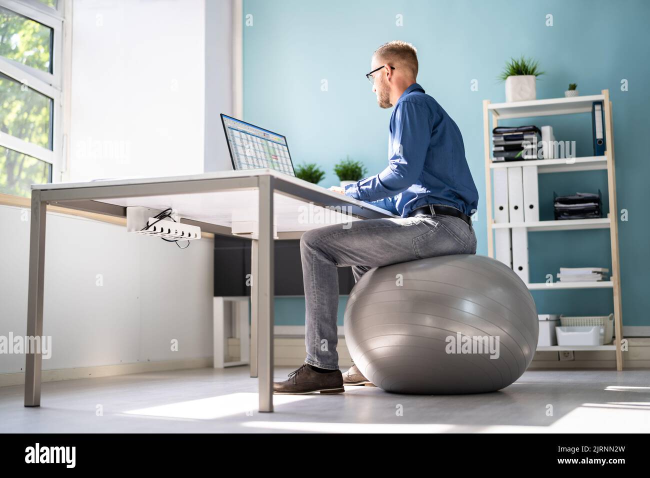 Posture correcte au bureau au bureau à l'aide d'un ballon de fitness Banque D'Images