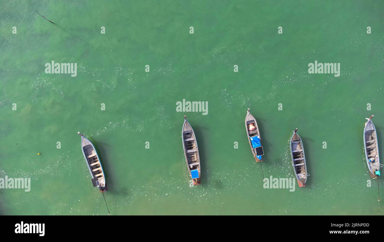 Beaucoup de bateaux de pêche près de la mer dans les îles tropicales. Jetée des villageois sur l'île sud de la Thaïlande. Vue de dessus des drones. Banque D'Images