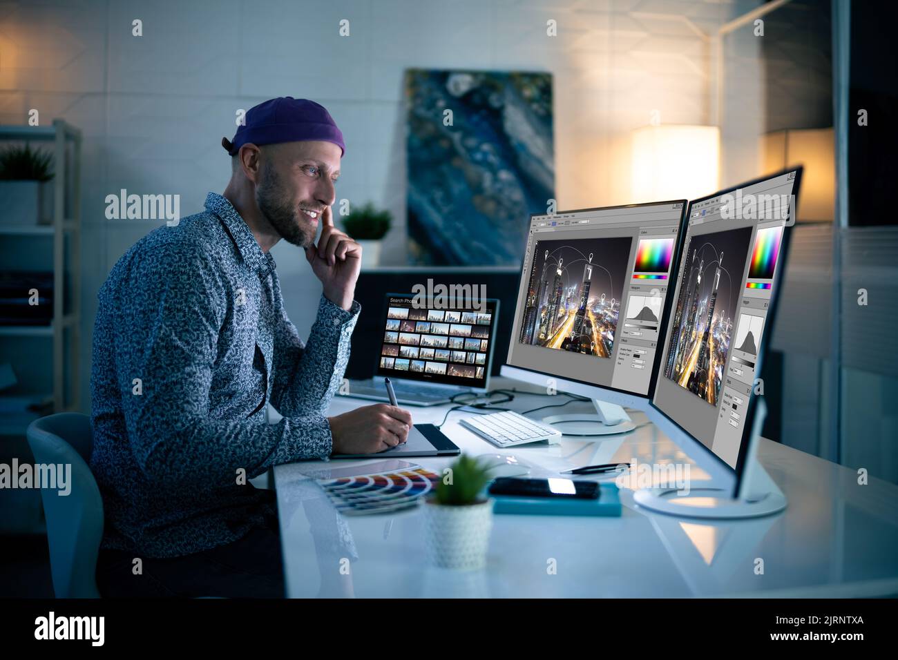 Graphiste travaillant tard dans la nuit au bureau Banque D'Images