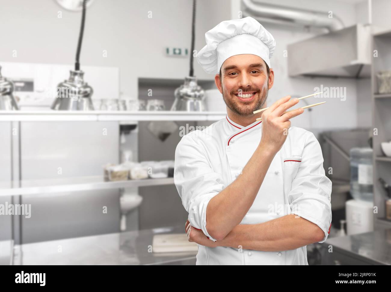 joyeux chef masculin souriant avec des baguettes Banque D'Images