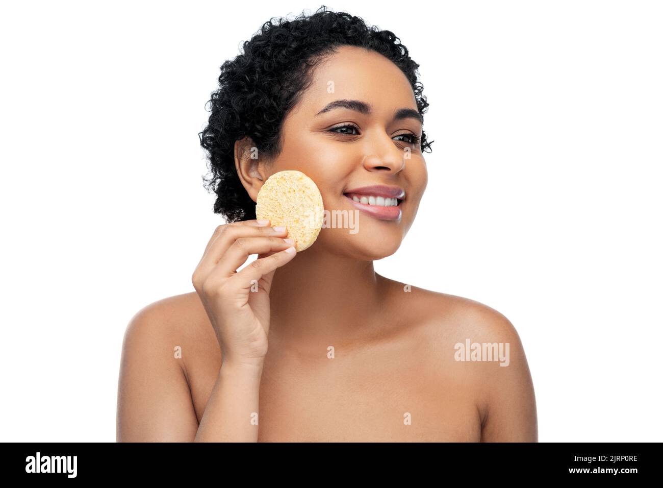 Jeune femme en train de nettoyer le visage avec une éponge exfoliante Banque D'Images