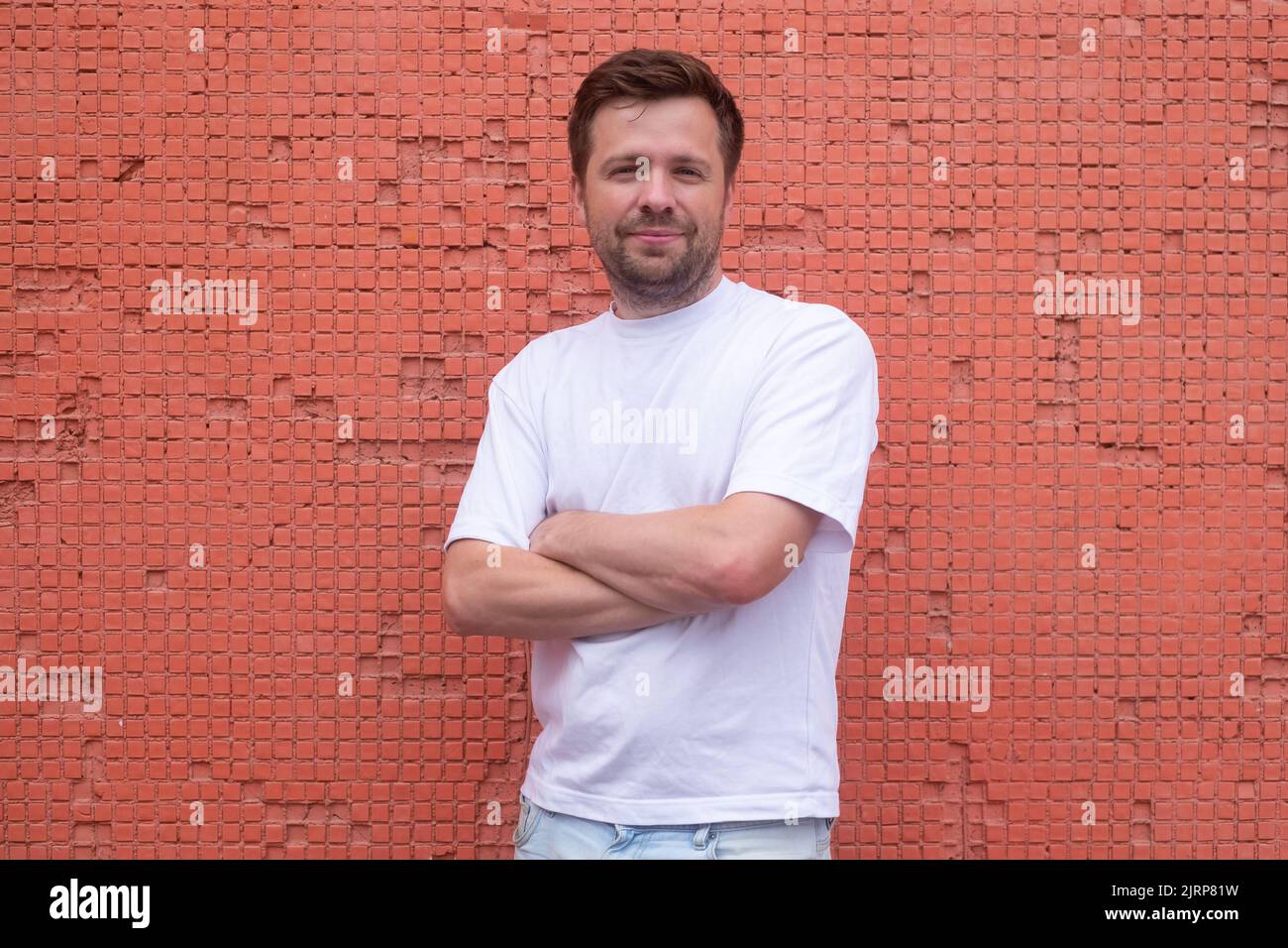 Jeune homme confiant posant avec des mains croisées Banque D'Images