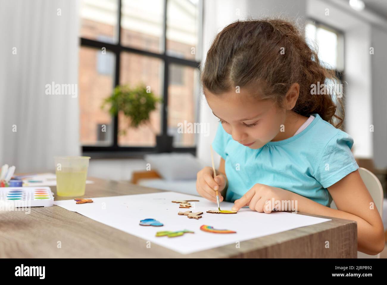 petite fille peinture des articles en bois à la maison Banque D'Images