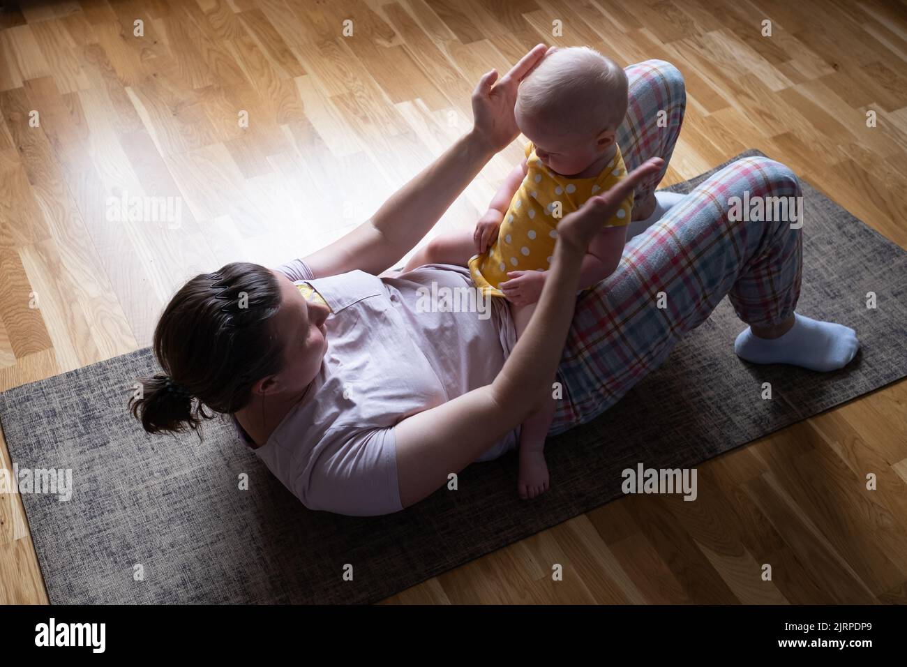 Mère caucasienne avec bébé faire le yoga à la maison pour être fort et en bonne santé, Banque D'Images
