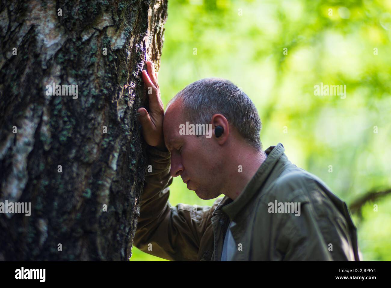 Un homme embrasse un arbre dans la forêt. Bois d'écorce.entretien pour l'environnement. L'écologie le concept de sauver le monde et d'aimer la nature par l'homme Banque D'Images