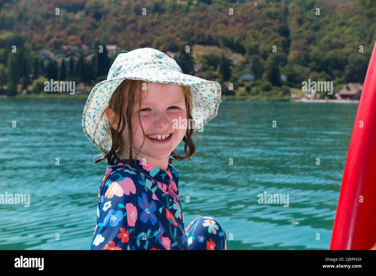 Enfant / enfant / enfants / enfants portant des chapeaux et des combinaisons d'éruptions cutanées profitant du soleil d'un pédalo sur le lac du Bourget en Savoie / Savoie, France. Journée d'été claire et ensoleillée avec ciel bleu. (131) Banque D'Images