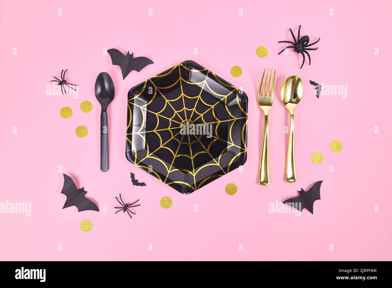 Assiette en papier de fête d'Halloween avec toile d'araignée et décoration de saison sur fond rose Banque D'Images