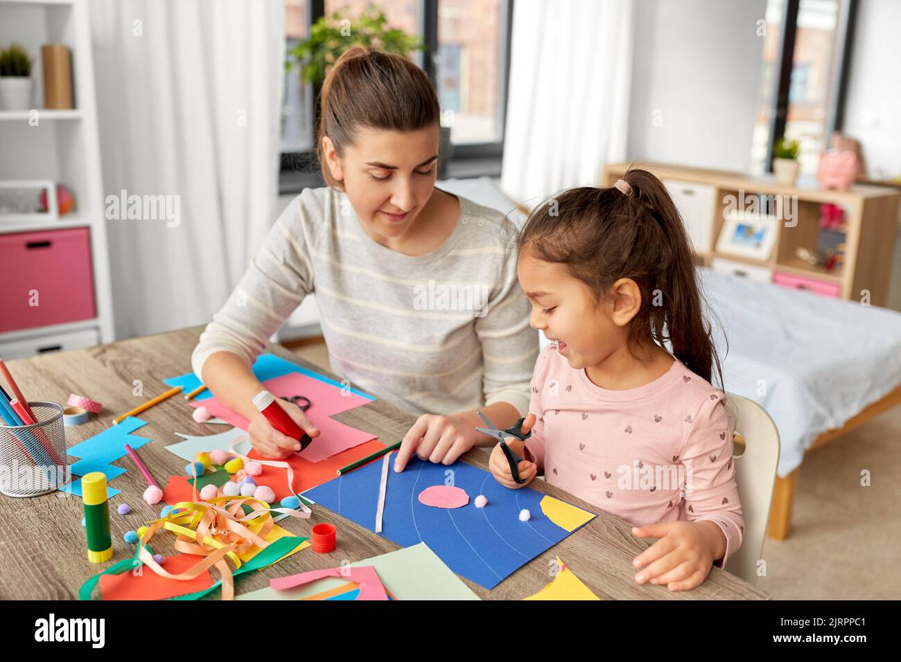 fille avec mère faisant l'application à la maison Banque D'Images