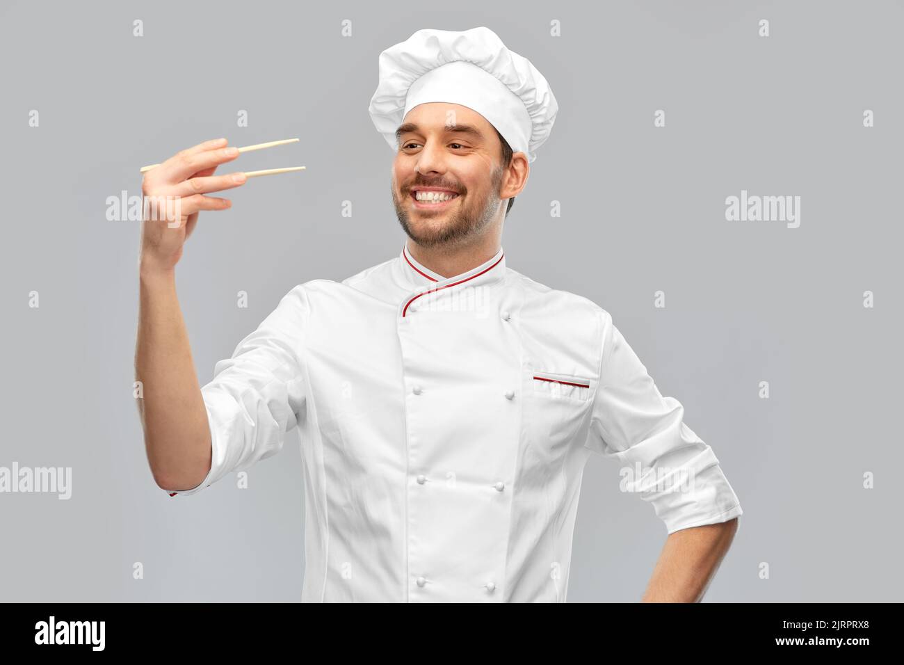 joyeux chef masculin souriant avec des baguettes Banque D'Images