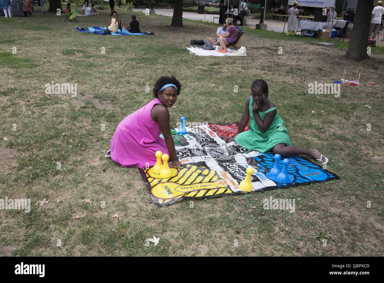 Des vendeurs de nourriture végétalienne noire et des organisations afro-américaines participent au Black VegFest au Commodore Barry Park à Brooklyn, New York. Les enfants jouent à un jeu de société sur la pelouse au festival.i Banque D'Images