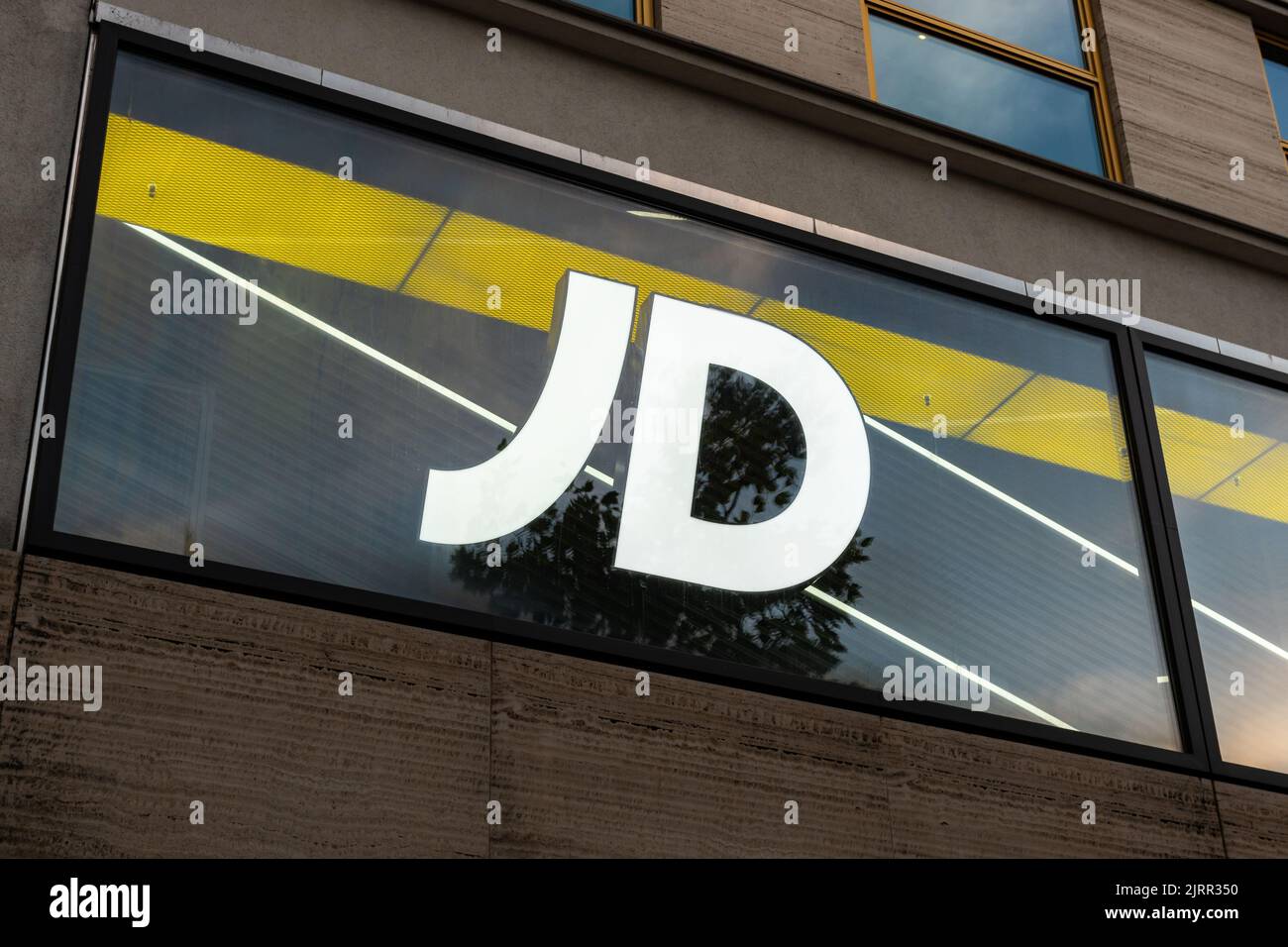 Logo JD Sports Fashion sur une façade de magasin. Lettres illuminées comme publicité du détaillant dans la ville. Acheter des vêtements et des chaussures de sport. Banque D'Images