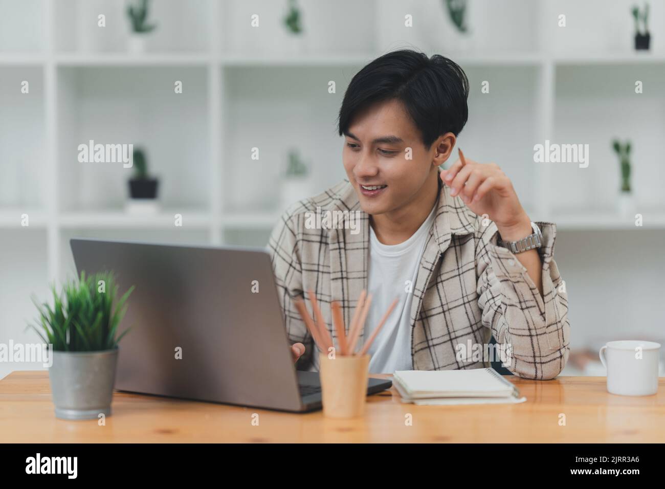 Homme asiatique utilisant un ordinateur portable travaillant au bureau Banque D'Images