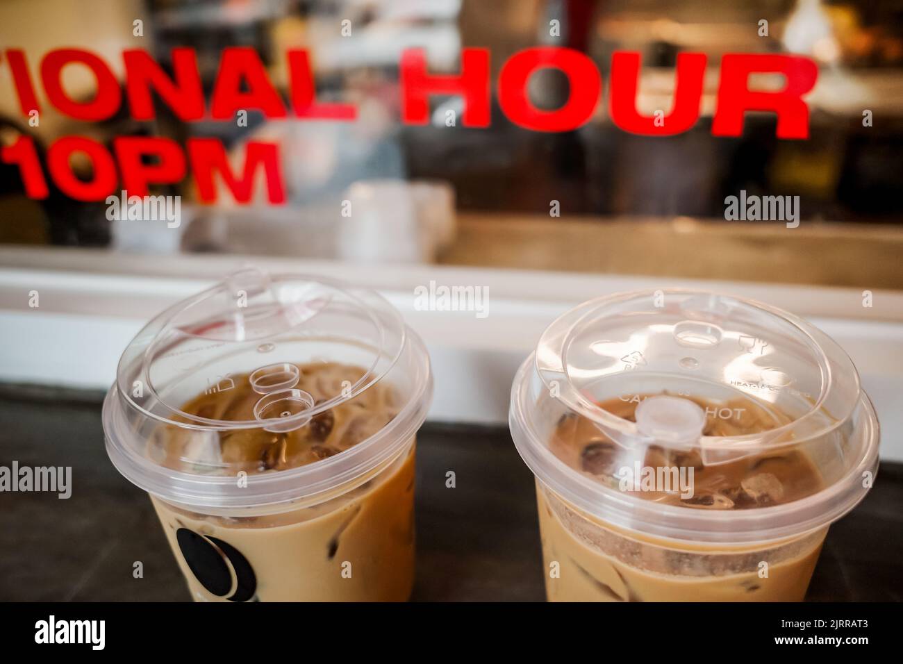 Café glacé servi dans une tasse en plastique jetable dans un restaurant Banque D'Images Café glacé servi dans une tasse en plastique jetable dans un restaurant Banque D'Images