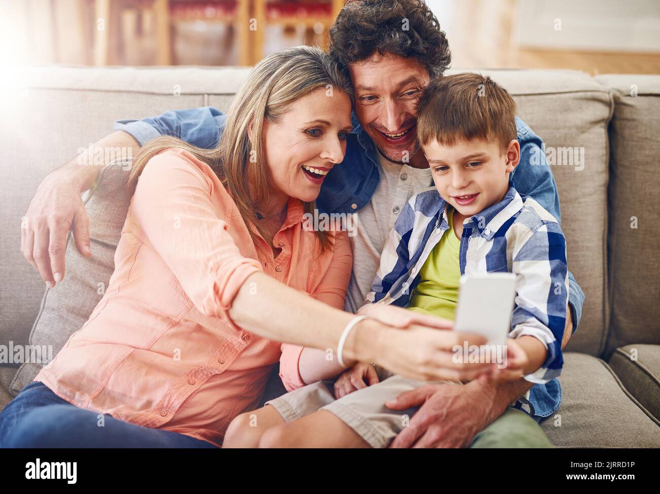 Faire des souvenirs précieux ensemble. Une famille qui prend un selfie à la maison. Banque D'Images