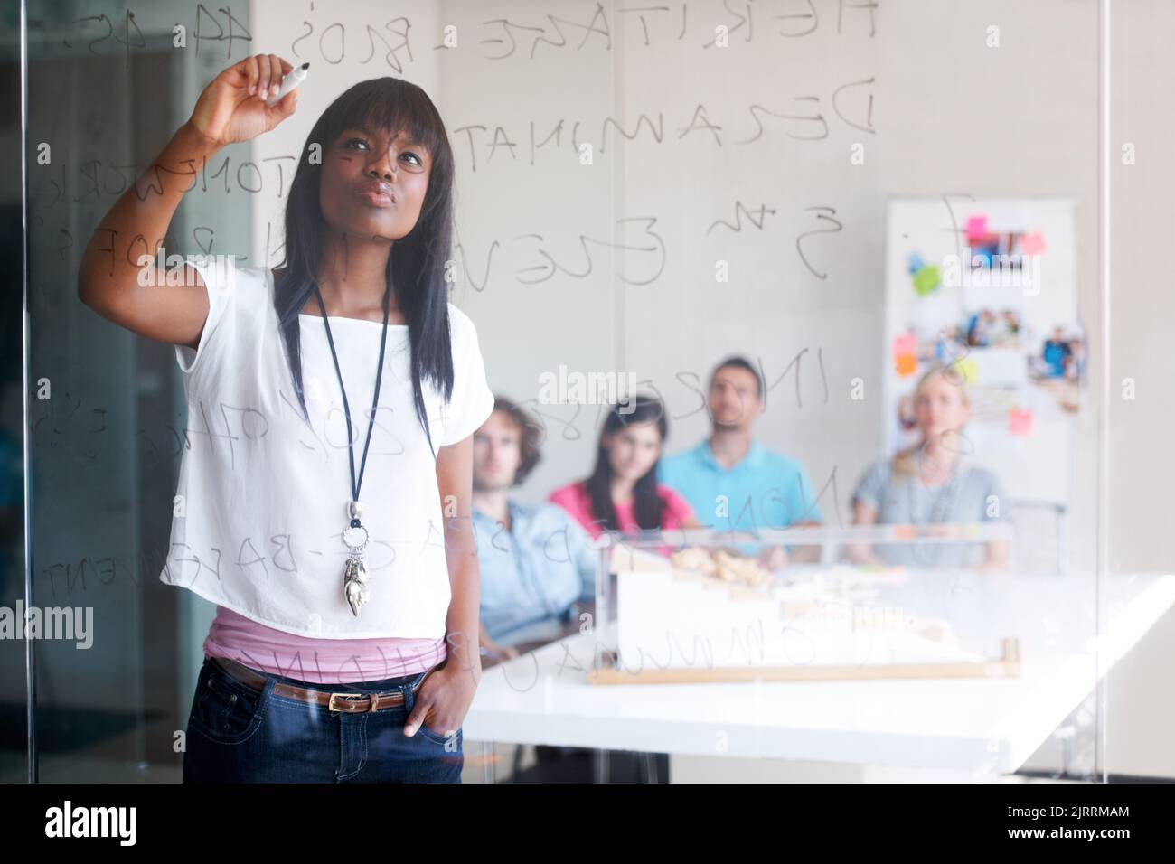 Une femme enseigne dans un atelier de conception, une formation ou une présentation avec une femme employée qui coache son équipe de personnel. Femme d'affaires noire qui parle à une équipe Banque D'Images