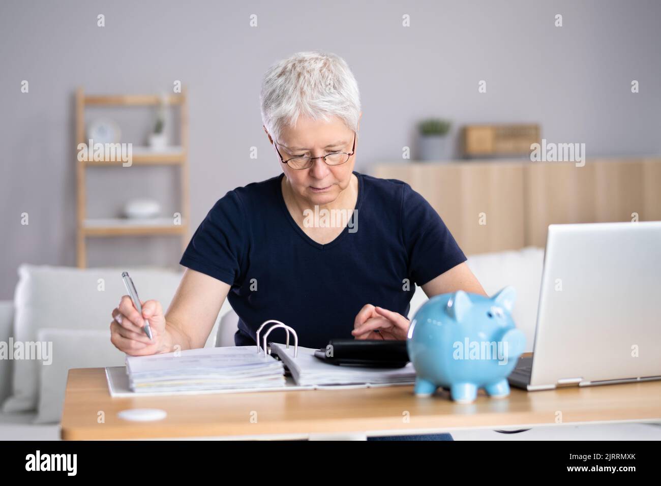 Femme âgée calculant des factures dans sa chambre Banque D'Images