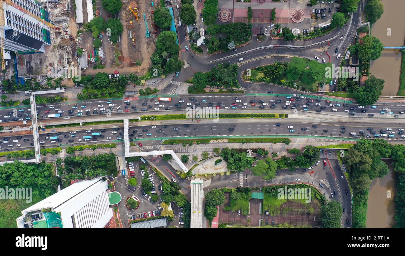 Vue de haut en bas de la circulation routière au coeur de la capitale Jakarta. Circulation animée dans le quartier des affaires le long de l'avenue Sudirman près de la rivière In Banque D'Images