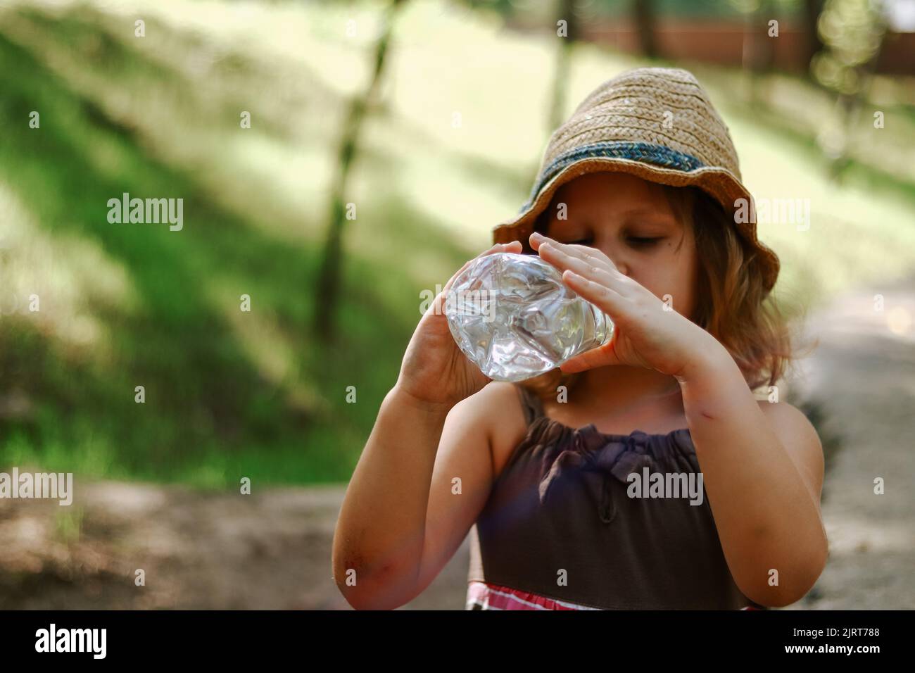 L'enfant boit de l'eau dans une bouteille en plastique. Bébé de 5 ans. Banque D'Images