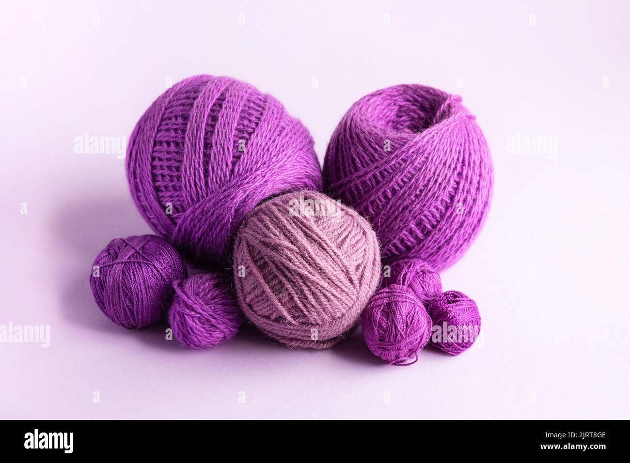 Lilas violet et laine tricotée rose sur fond lilas pour tricoter des vêtements chauds et des hobbies Banque D'Images