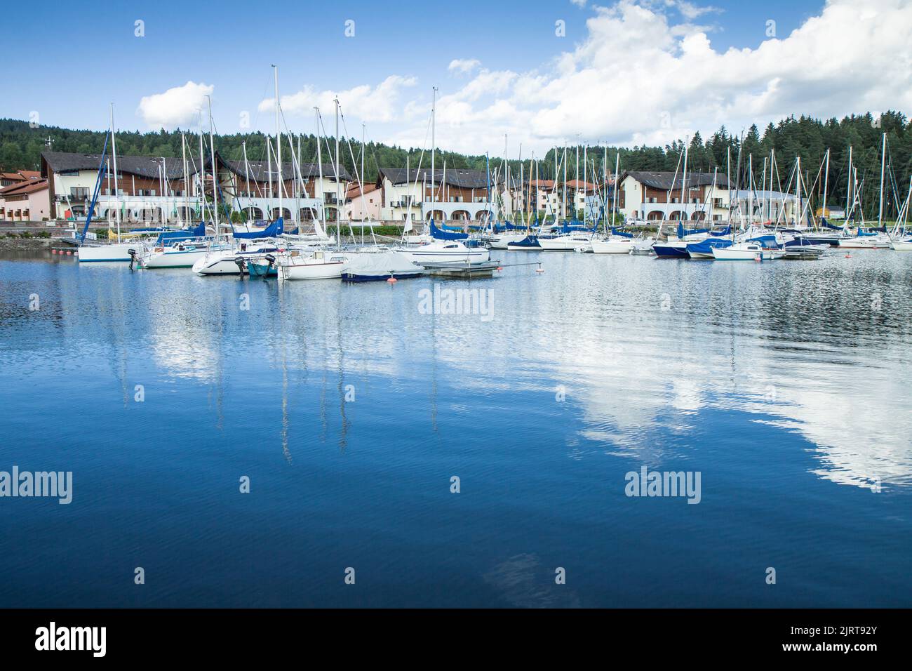 Belle vue sur les bateaux à voile se reflétant sur la surface de l'eau. Joli port moderne en arrière-plan. Lipno nad Vltavou, République Tchèque. Journée ensoleillée incroyable Banque D'Images