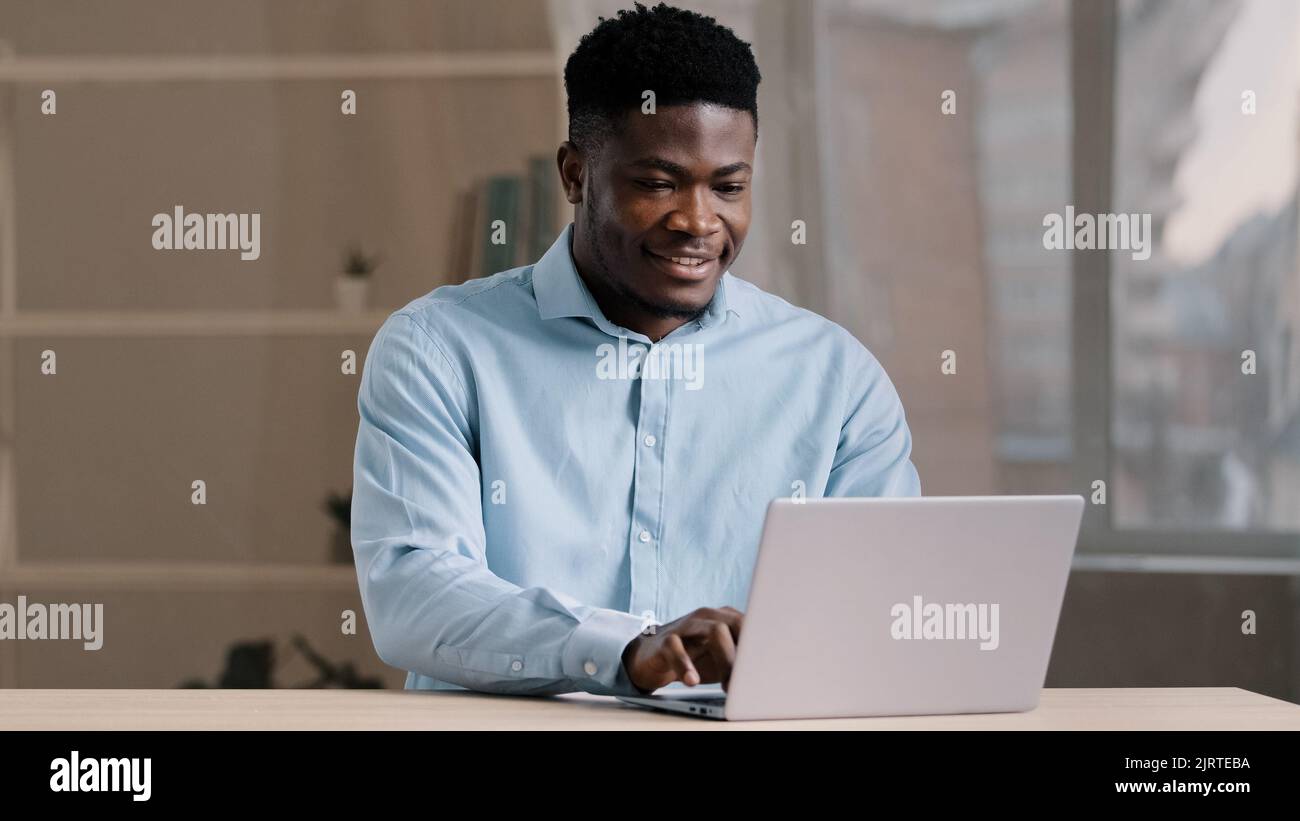Homme d'affaires afro-américain professionnel travailleur homme programmeur homme dans chemise bleue travail freelance à domicile bureau tapant e-mail sur ordinateur portable personnel Banque D'Images