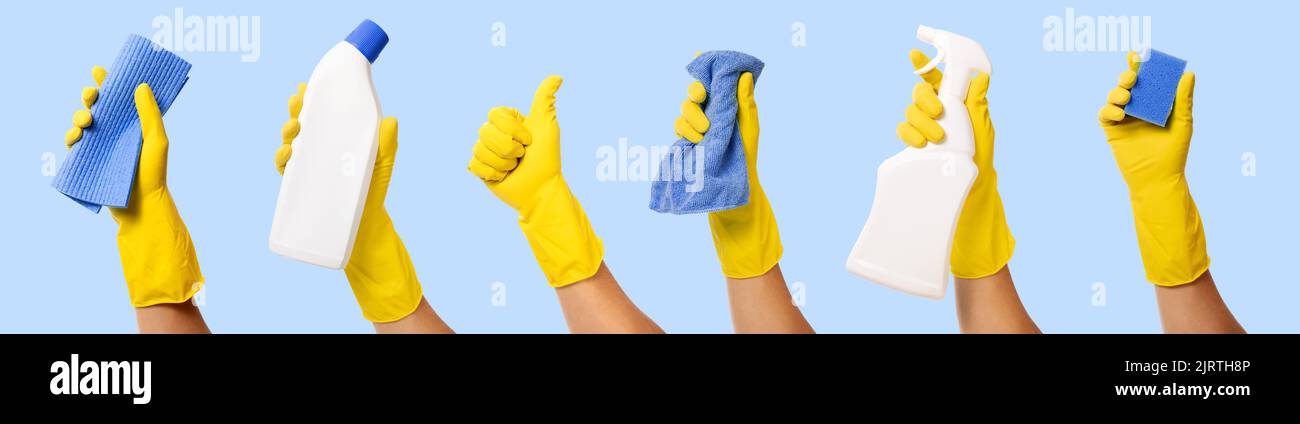 main avec gant en caoutchouc jaune contenant les fournitures de nettoyage isolées sur fond bleu. bannière Banque D'Images