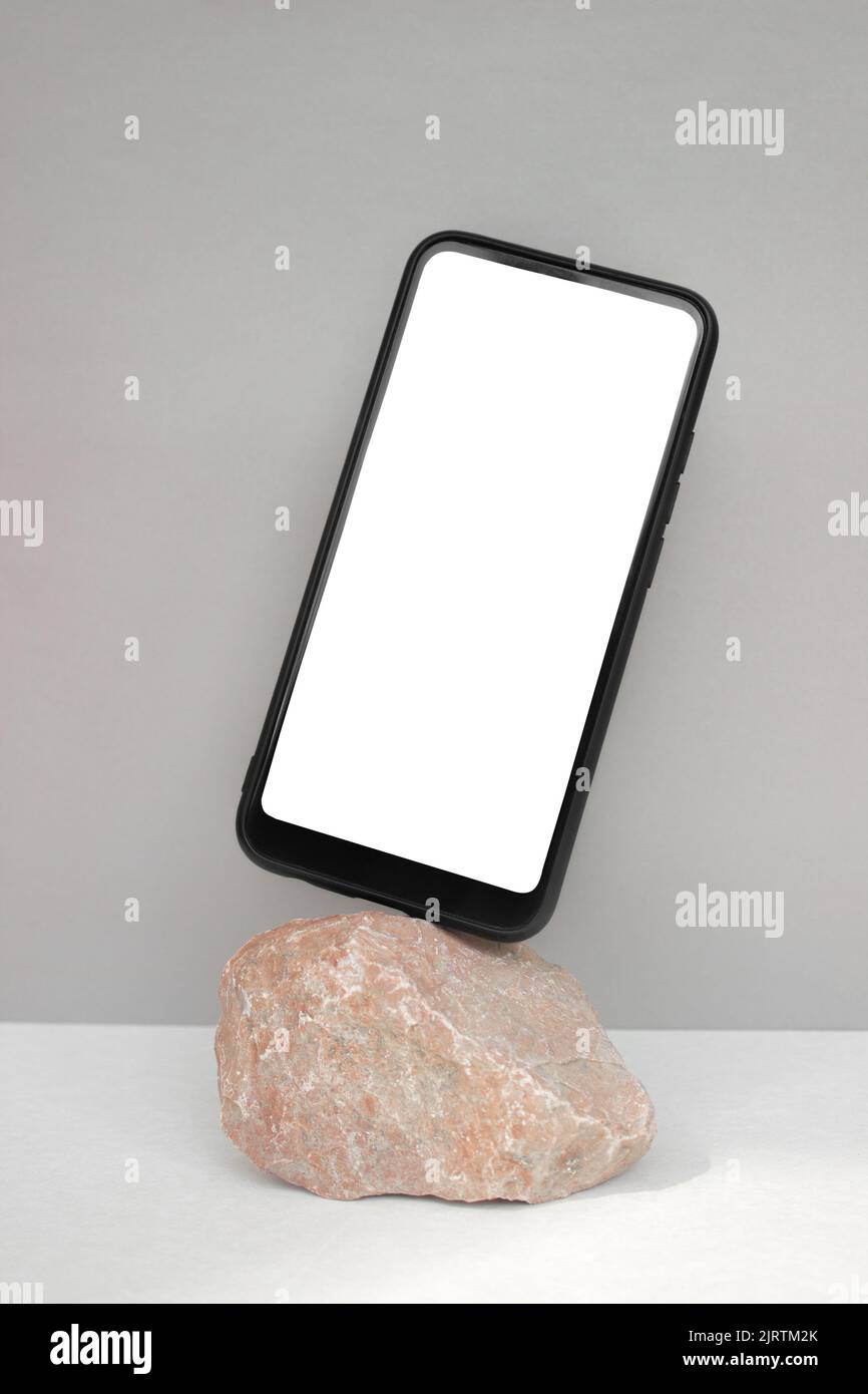 Modèle de smartphone Mockup sur pierre rouge naturelle sur fond gris.style minimaliste. Photo verticale Banque D'Images