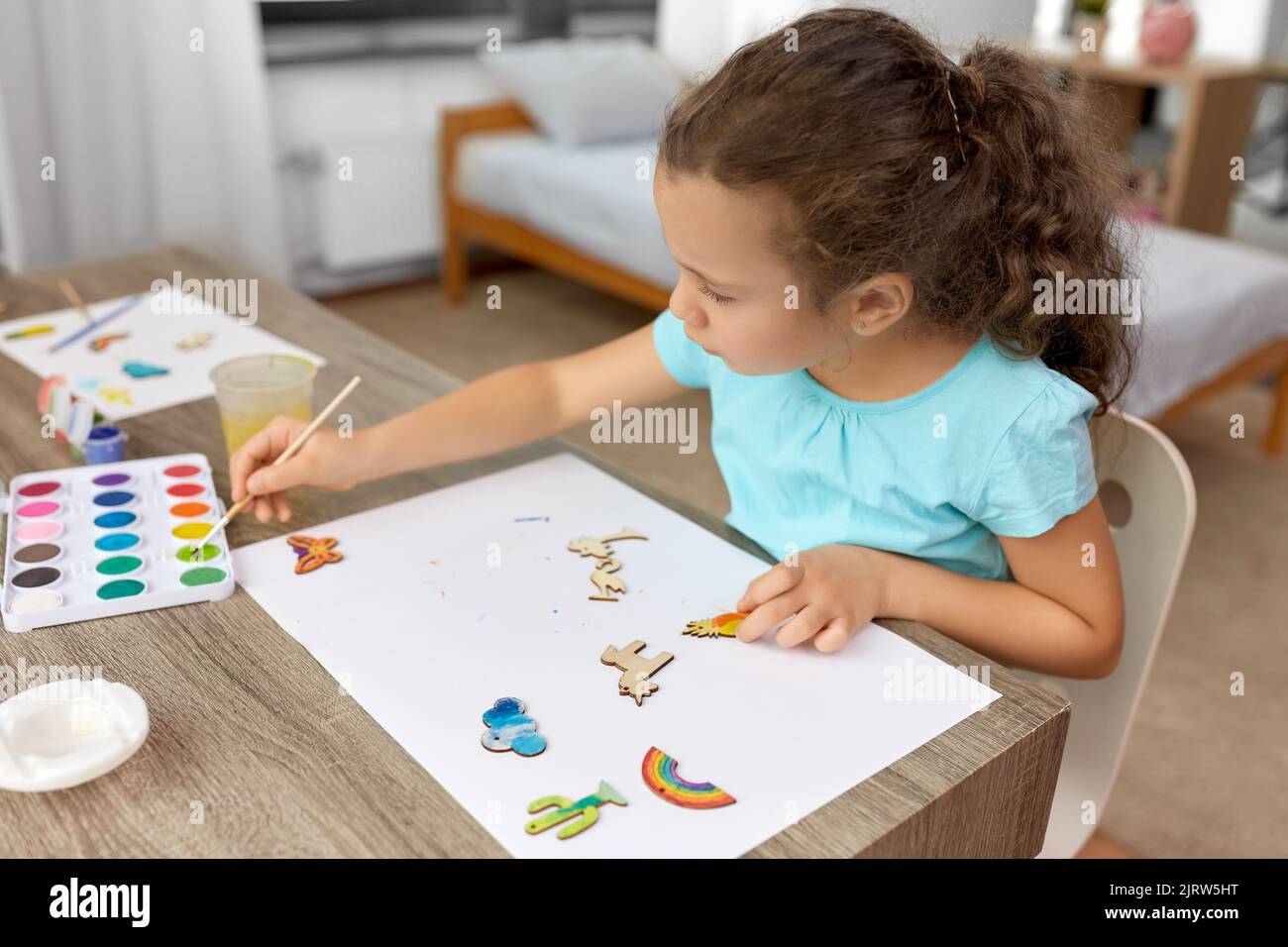 petite fille peinture des articles en bois à la maison Banque D'Images