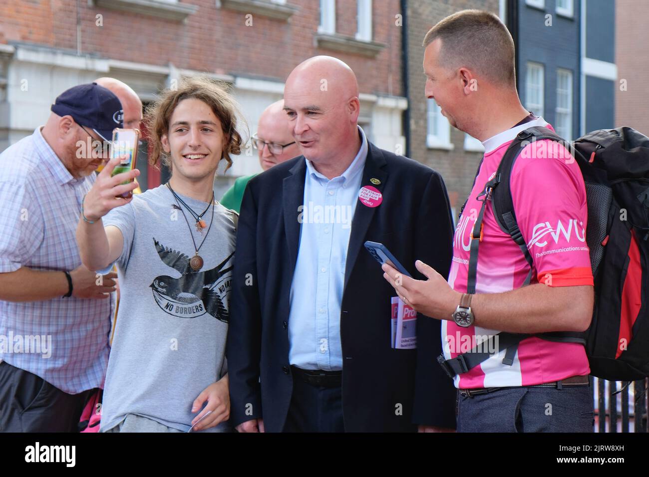 Londres, Royaume-Uni, 26th août 2022. le secrétaire général du syndicat RMT, Mick Lynch, pose un selfie lors d'un rassemblement de travailleurs postaux à l'extérieur du bureau de tri de Mount Pleasant. Plus de 100 000 travailleurs postaux du Royal Mail, membres du Syndicat des travailleurs de la communication (CMU), ont organisé la première des quatre sorties en déroute dans un conflit sur la rémunération, où une augmentation de salaire de 5,5% a été rejetée au motif qu'elle est à la traîne de l'inflation et ne couvre pas le coût actuel de la vie. Crédit : onzième heure Photographie/Alamy Live News Banque D'Images