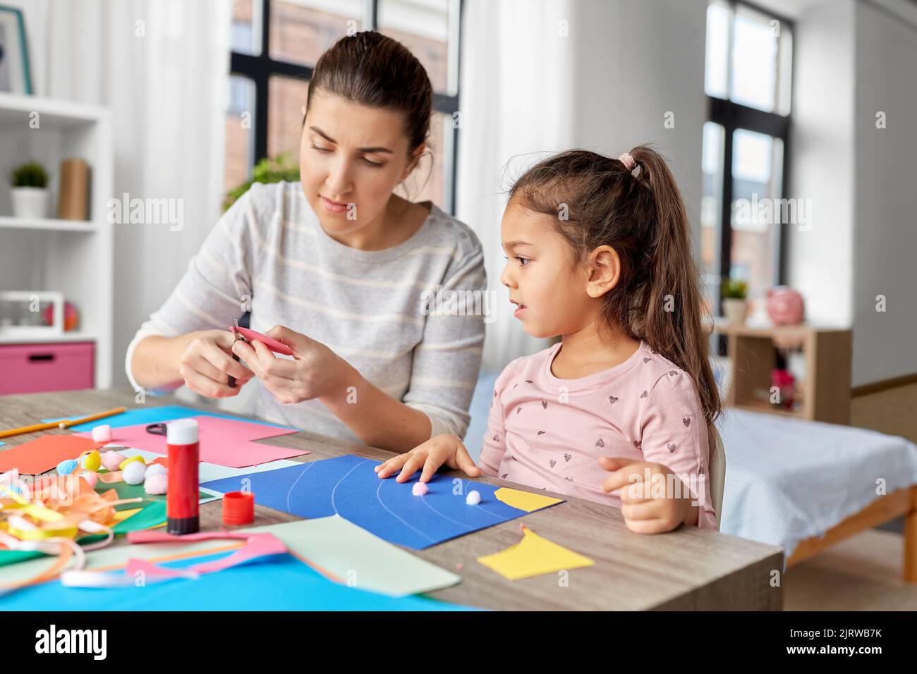 fille avec mère faisant l'application à la maison Banque D'Images