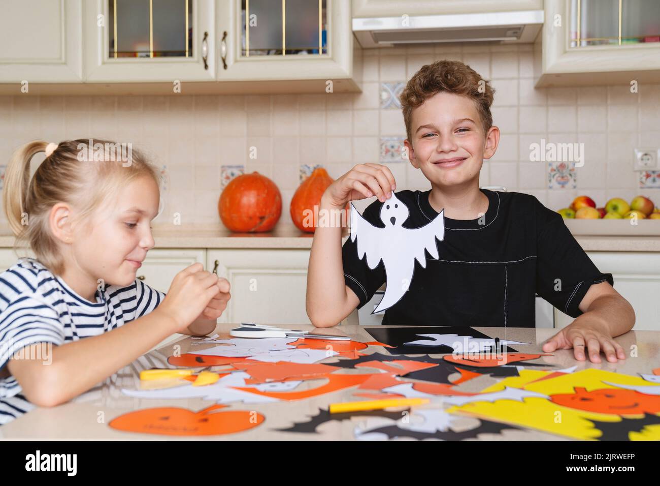 Les enfants préparent des objets artisanaux en papier coloré pour l'Halloween. Banque D'Images