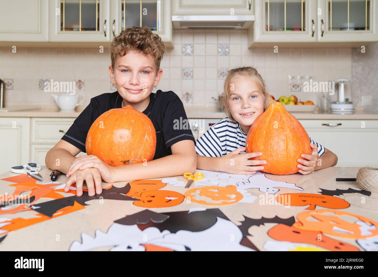 Les enfants avec des citrouilles préparent l'artisanat pour les vacances d'Halloween. Banque D'Images