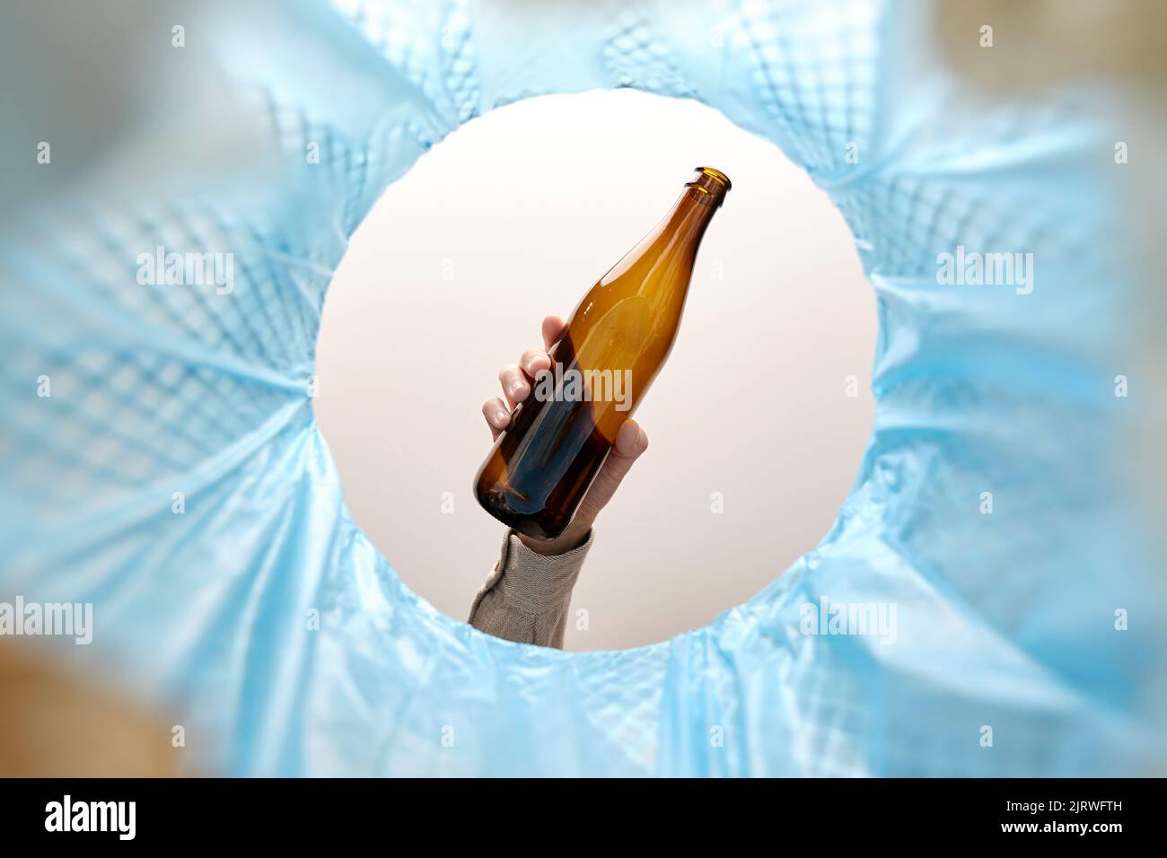 jeter la bouteille de verre à la main dans la poubelle Banque D'Images