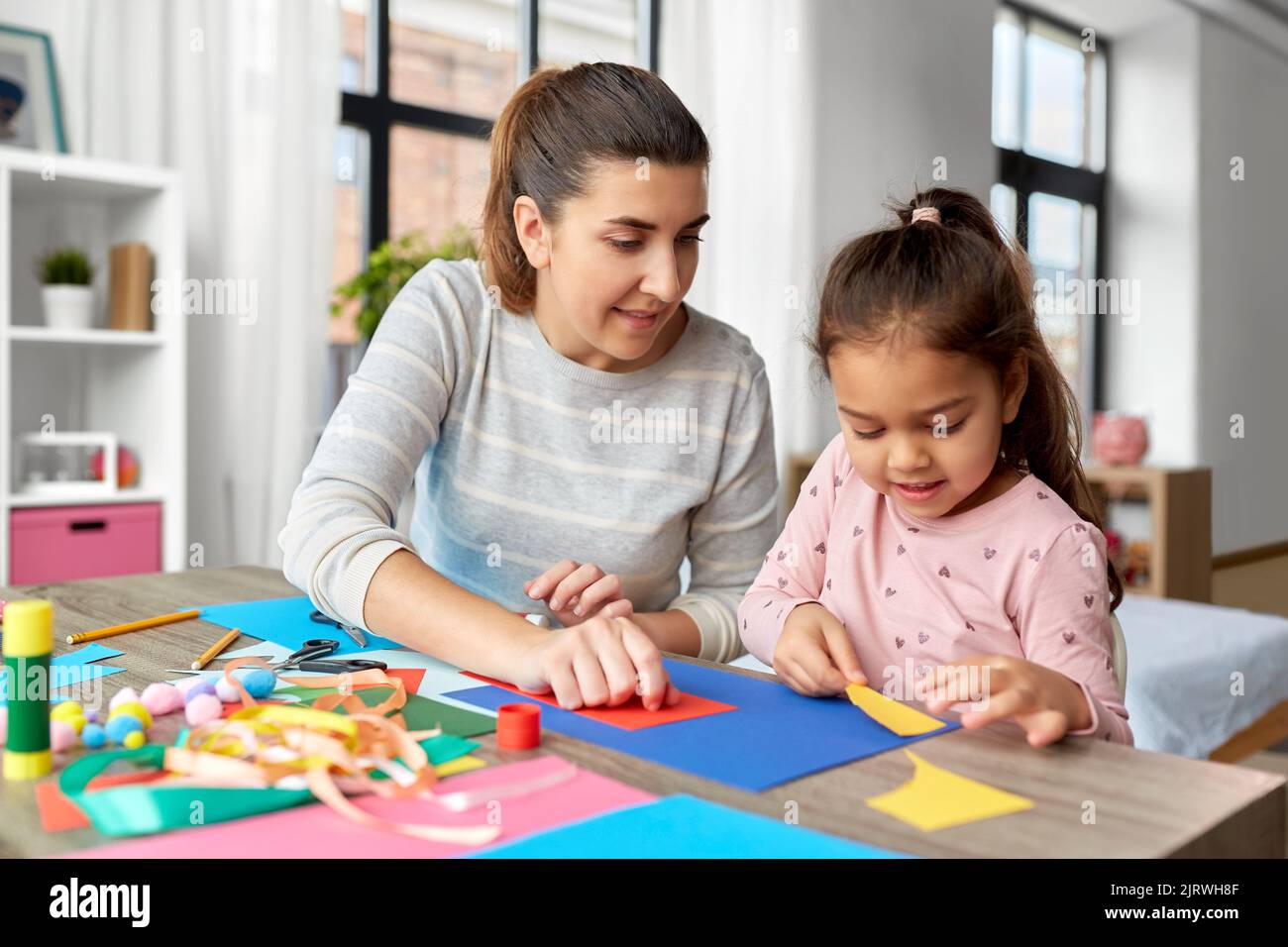 fille avec mère faisant l'application à la maison Banque D'Images