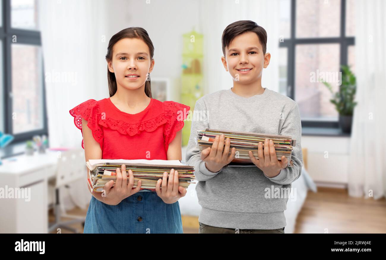 des enfants heureux avec des magazines triant les déchets de papier Banque D'Images