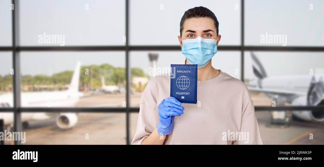 femme sous masque et gants portant un passeport d'immunité Banque D'Images