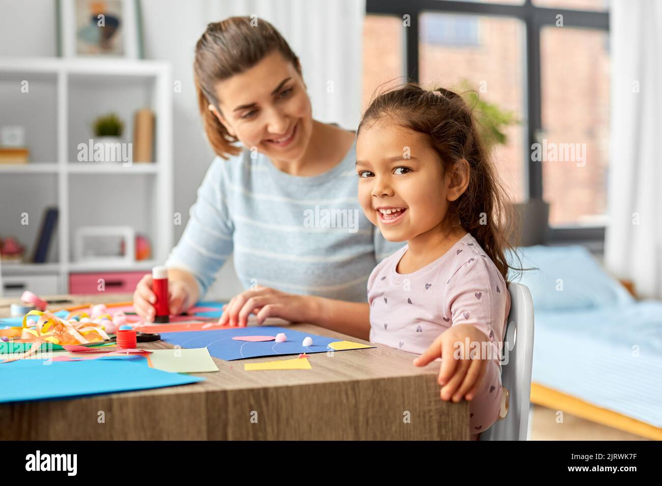 fille avec mère faisant l'application à la maison Banque D'Images